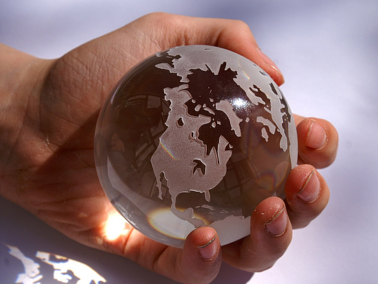 Weltkugel aus Glas kleine Glaskugel mit Weltkarte wird in der Hand gehalten