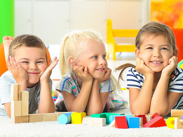 4 Kinder auf einem Spielteppich im Kindergarten