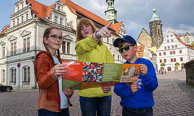 Kinderstadtplan Drei Kinder schauen sich den Kinderstadtplan für Pirna an