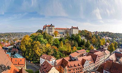 Blick auf Schloss Sonnenstein und Dächer der Stadt im Herbst