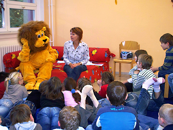Vorlesen in der StadtBibliothek Pirna Vorlesepatin und Maskottchen Bibolin lesen Kindern in der Bibliothek vor