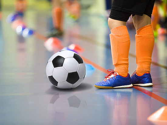 Sportvereine in Pirna Kind spielt Fußball in einer Halle