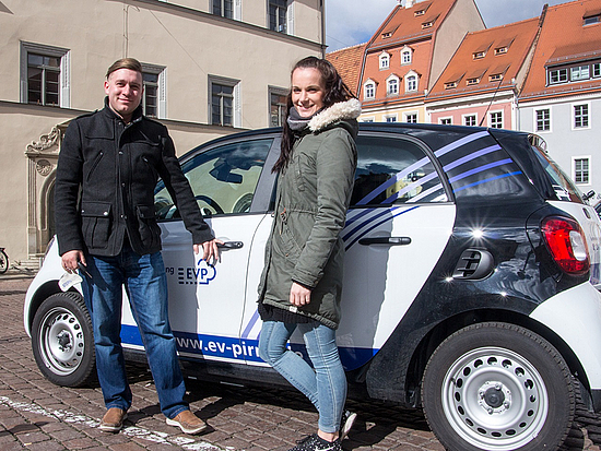 Aktionstag Klimaschutz Zwei Stadtmitarbeiter vor einem Elektroauto der EVP