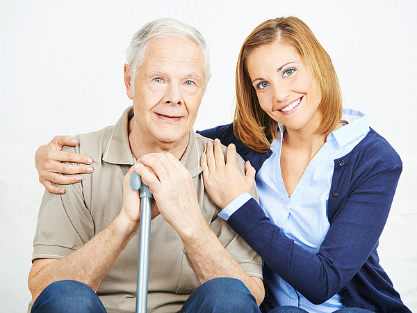 Pflege in Pirna Pflegedienstmitarbeiterin unterstützt Senior mit Gehstock